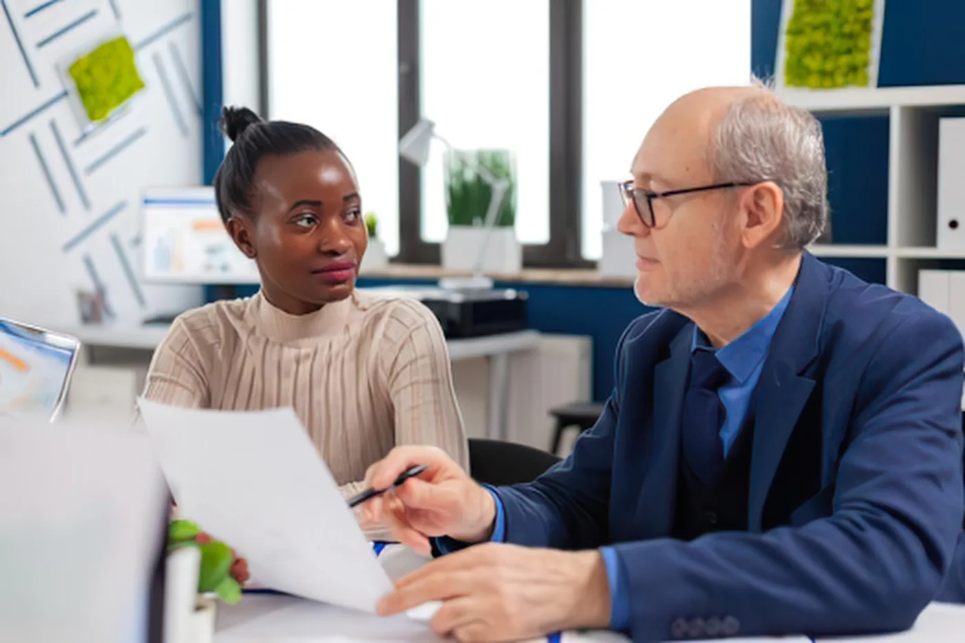 Mentor revisando documentos profesionales con una joven