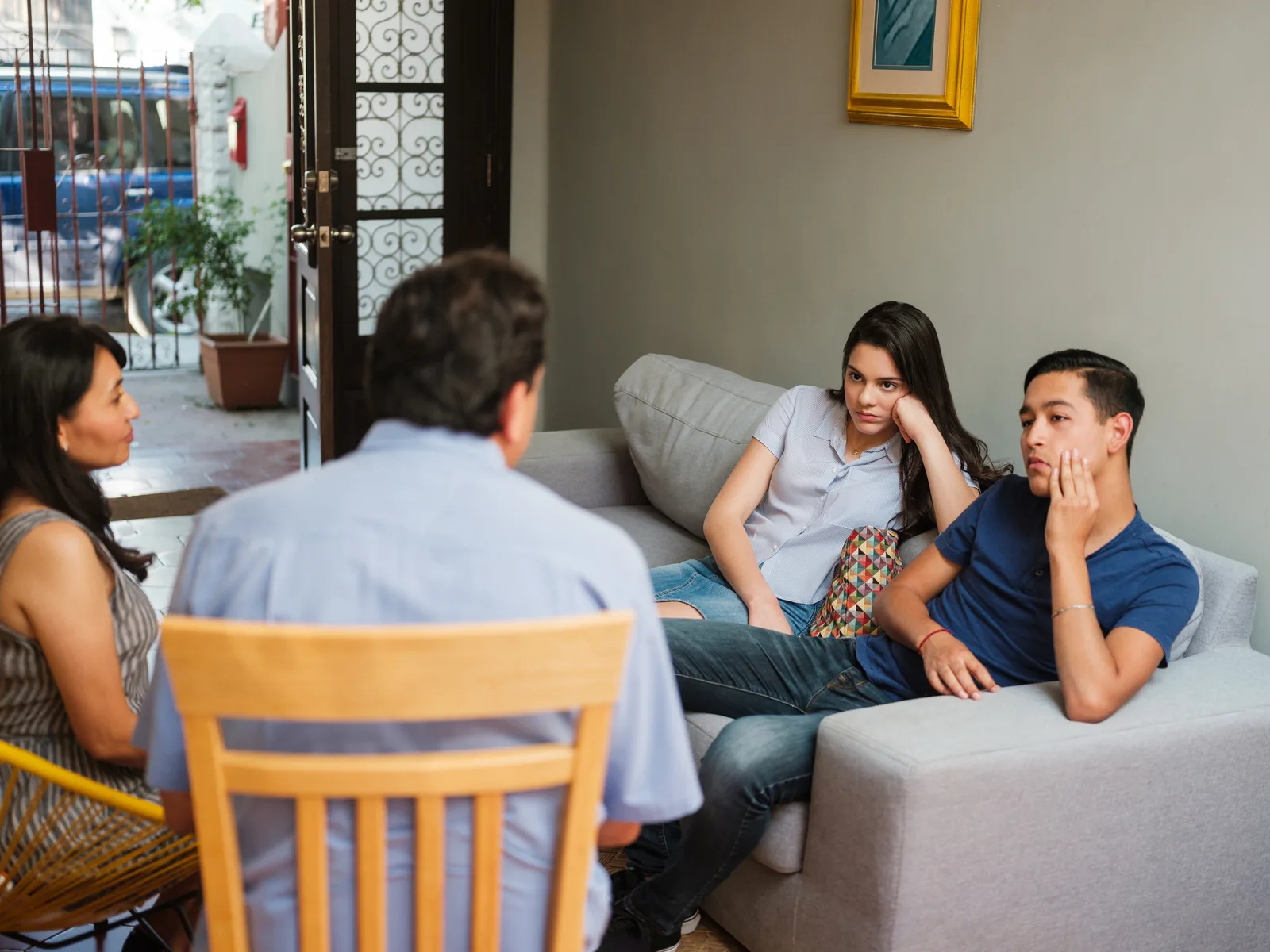 Familia conversando con jóvenes en casa